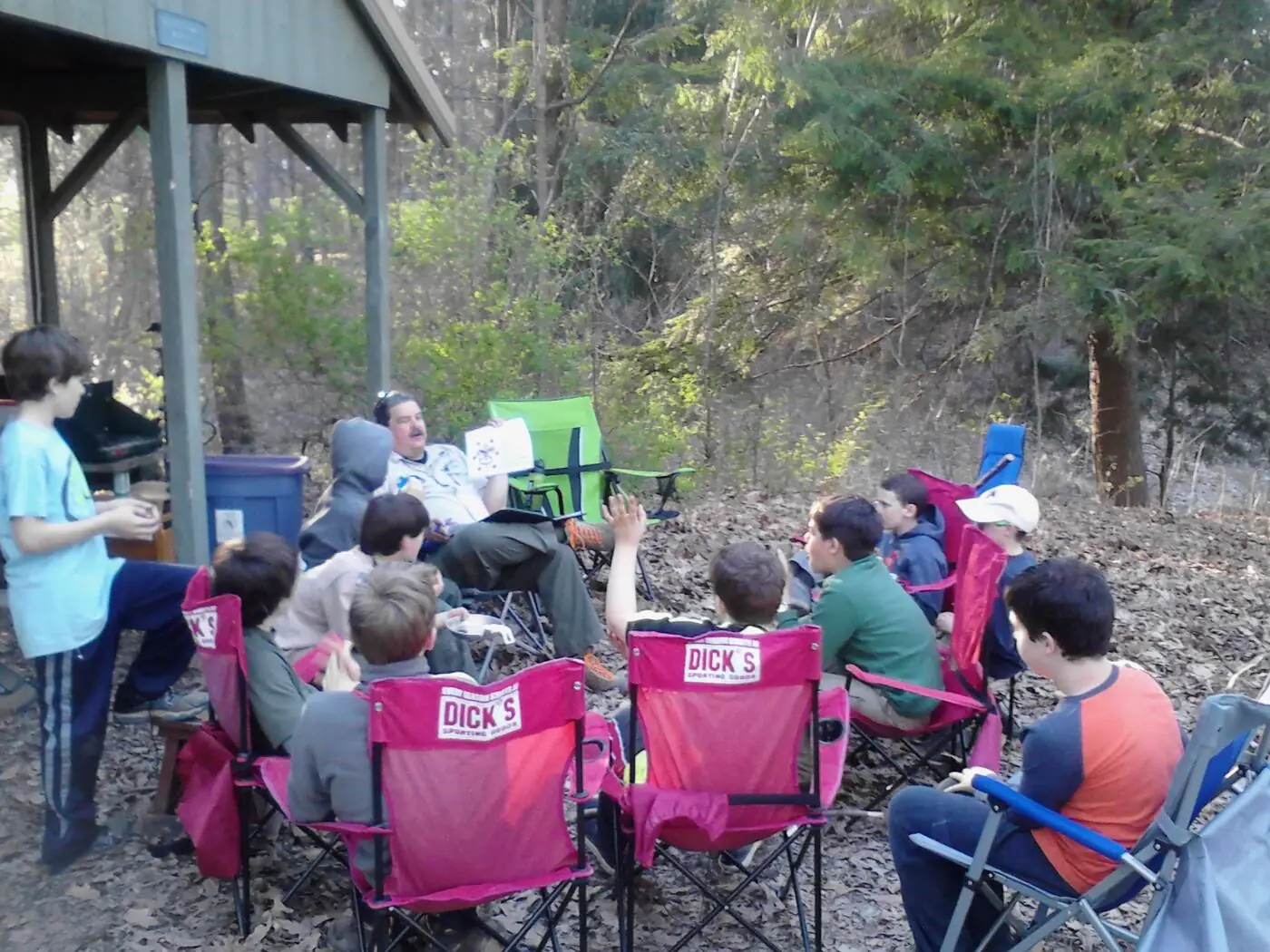 Scouts and their parents around a campfire outdoors